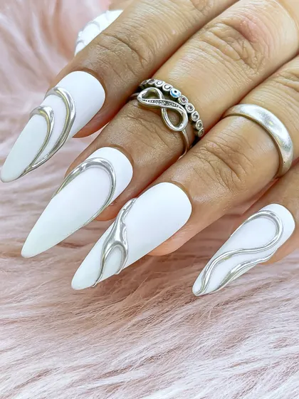 A full hand view of the metallic chrome nail art, complemented by silver rings for a cohesive, edgy look.