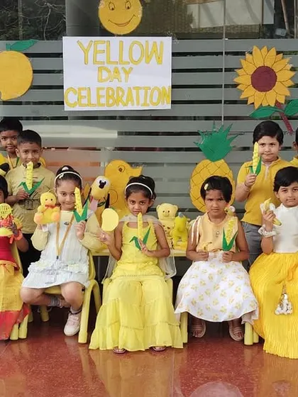 Students hold up corn cobs, learning about yellow foods and objects as part of our immersive Yellow Day activities.