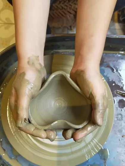 Little hands carefully shaping a heart from clay. This image captures the personal and emotional connection children make with their creations.