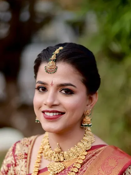 A close-up portrait of the bride, her happy smile lighting up her face. The makeup enhances her natural beauty and gives her a radiant glow.