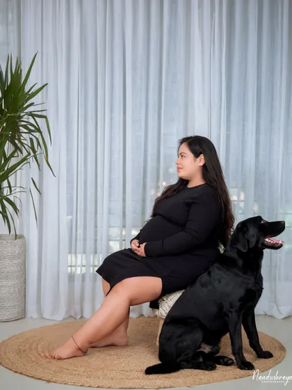 A peaceful moment with a furry family member. This mother-to-be shares a quiet minute with her loyal black lab, who is already a protective big brother.