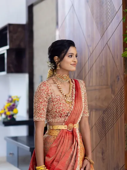 A side profile showcasing the intricate hairstyle and beautiful gold jewellery.