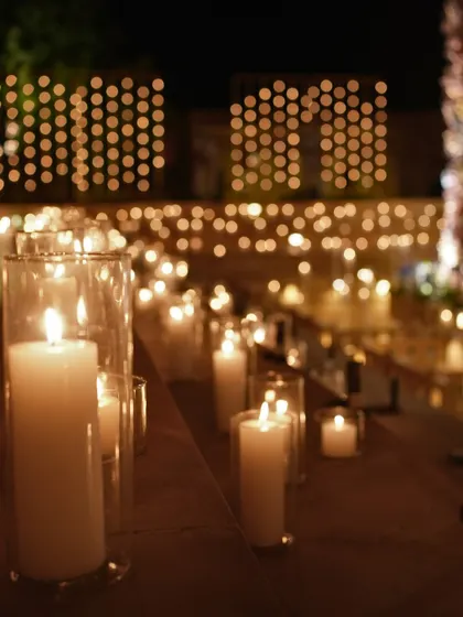 The warm, golden glow of countless candles lining the steps of the Suryagarh courtyard, creating a dramatic and romantic pathway to the central mandap.