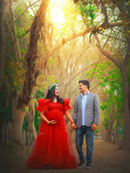 A romantic walk through a tree-lined path. The vibrant red tulle gown stands out beautifully against the natural greenery, creating a storybook feel.