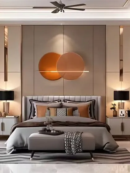 This contemporary bedroom design features circular art pieces and metallic accents on the wall. The glossy wardrobe doors and plush rug add to the room's modern and luxurious feel.