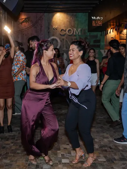 Two dancers sharing a smile and a great dance at our weekly social. It is all about connecting with others who share your passion for Latin dance.