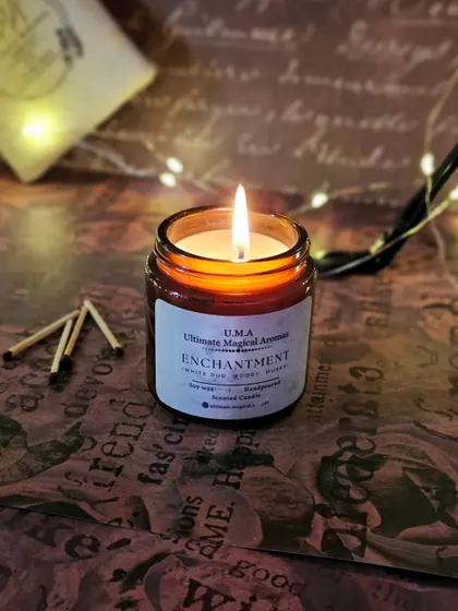 My 'Enchantment' Amber Jar Candle, lit and casting a warm, inviting glow. The white oud fragrance is perfect for creating a tranquil, wintery mood.