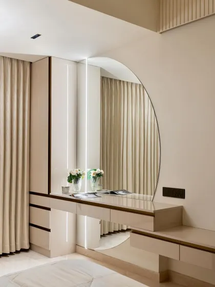 The master bedroom's integrated vanity unit, featuring a sleek angular mirror and built-in lighting for a functional and glamorous getting-ready space.