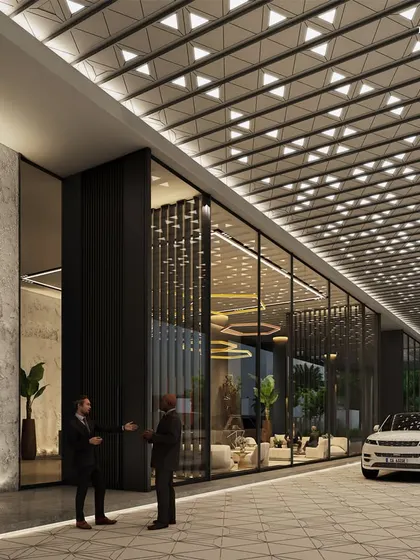 The grand entrance of the Worli commercial tower, where a patterned, illuminated ceiling welcomes visitors. The design uses expansive glass and textured stone to create a powerful first impression of elegance and innovation.