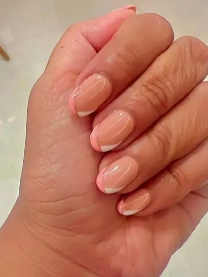 A soft and pretty design featuring a pink base with classic white French tips and a delicate, thin line of silver glitter to separate the colors.