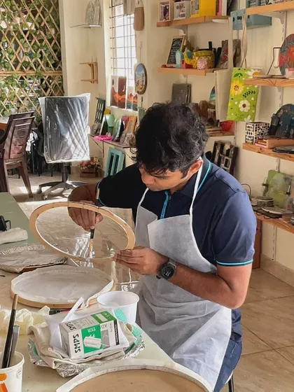 A participant carefully assembling his moon lamp. The process involves both creating the texture and then wiring the light for the final effect.