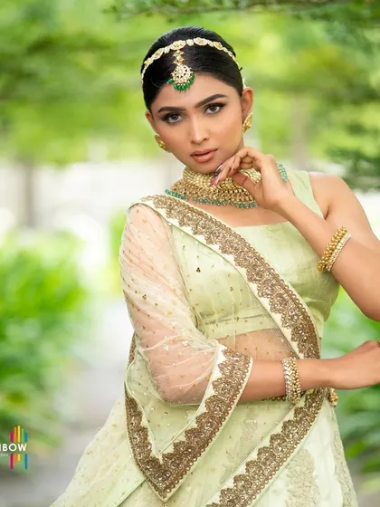 A confident pose in our light green designer lehenga. The sheer dupatta with a heavy gold border adds a touch of luxury to this fresh and elegant ensemble.
