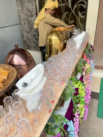 Another view of our tea station, with staff preparing to serve guests. The use of traditional copper and brass urns adds a classic touch to the setup.