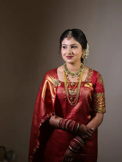 An elegant portrait of the bride. Her makeup is soft and romantic, and her hair is styled in a classic updo with flowers.