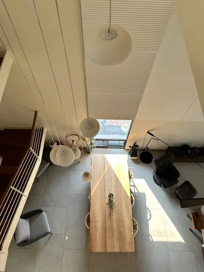 An overhead view of the dining area, which is illuminated by a skylight and a cluster of pendant lamps. This highlights my focus on using natural and artificial light to define a space.