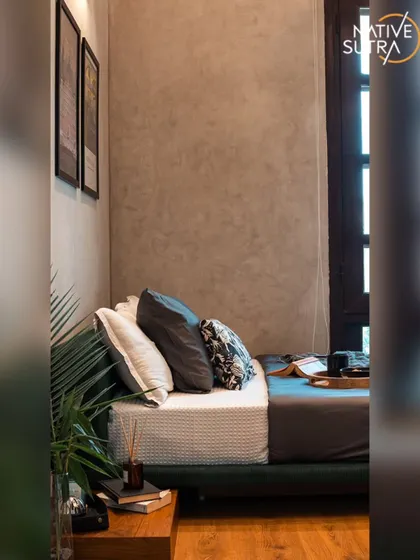 We designed this loft-style bedroom with a minimal, industrial aesthetic. The concrete-textured walls and low-profile bed are balanced by the warmth of the wooden floor and side table, creating a serene space for a young creative.