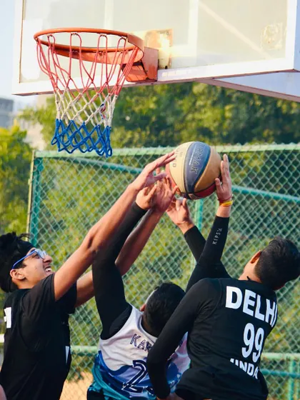 Three players go up for a rebound in this action-packed shot. Moments like these highlight the importance of positioning, timing, and determination under the basket.