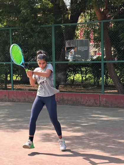 A player mid-swing during a practice session. The focus and determination are clear, all part of the supportive training environment we foster.
