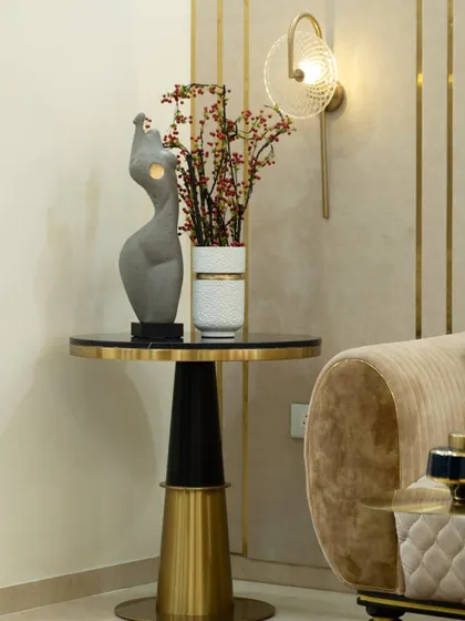 This little nook is just perfect. A sleek side table in black and gold holds a sculptural manikin and a vase with bright berries, adding a touch of elegance and artistry without overdoing it.