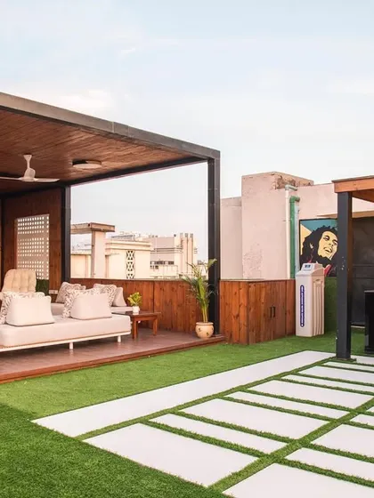 The terrace includes a custom bar and barbecue area, perfect for hosting parties. The quirky art adds a pop of color and personality, making the space feel fun and unique.