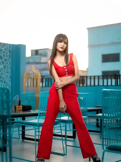 A full-length shot from a rooftop location, showcasing the complete western-style outfit and the bold makeup that complements it.