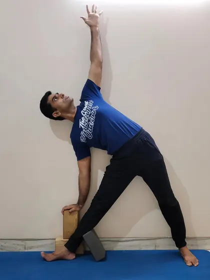 Using props is a key part of making yoga accessible. In this photo, I am using blocks in Triangle Pose (Trikonasana) to bring the floor closer, which helps maintain proper alignment and stability. This is a technique I frequently use in my classes to support all participants.