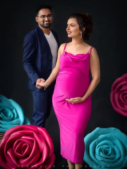 A beautiful portrait of the mom-to-be, with her partner looking on lovingly in the background. The composition tells a story of support and admiration.