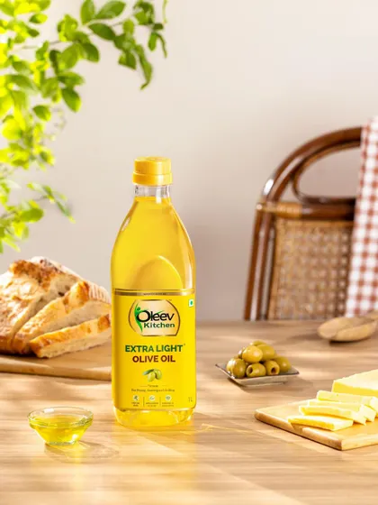Capturing Oleev's Extra Light Olive Oil in a naturally styled, warm kitchen setting. The composition uses soft, natural light and fresh ingredients to reinforce the product’s culinary versatility and homey feel.