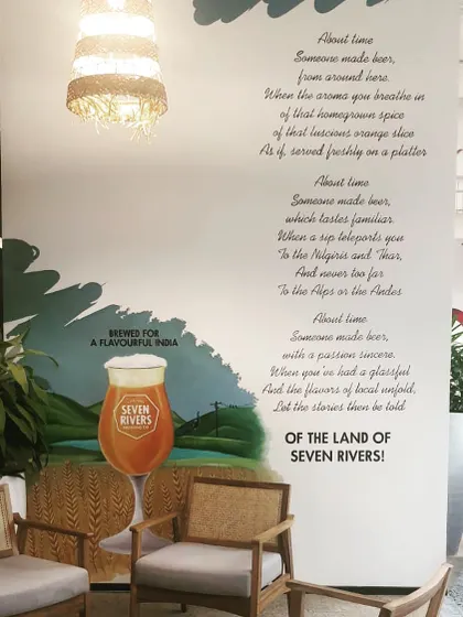 For the 'Seven Rivers' brand at the AbInbev office, we created this cozy nook. The wall features a hand-written poem about the brand's story, paired with painted imagery that evokes a sense of place and flavour.