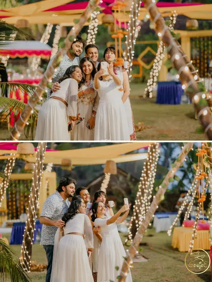Guests taking a group selfie amidst the beautifully lit outdoor Sangeet venue.