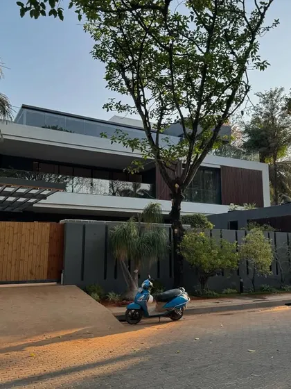 A daytime view of a modern Bangalore residence, showing the clean lines, cantilevered structures, and a mix of materials that define our contemporary architectural style.