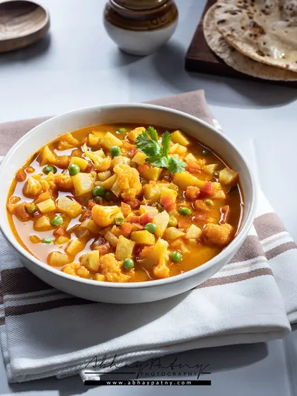 A simple, home-style bowl of Mix Veg curry. The bright, clean lighting makes it look wholesome and nutritious, just like a meal you'd have at home.