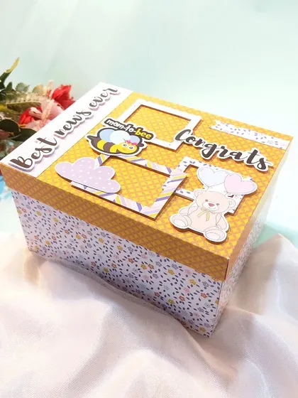 The box for the mom-to-be hamper, decorated with cute "Congrats" and teddy bear embellishments.