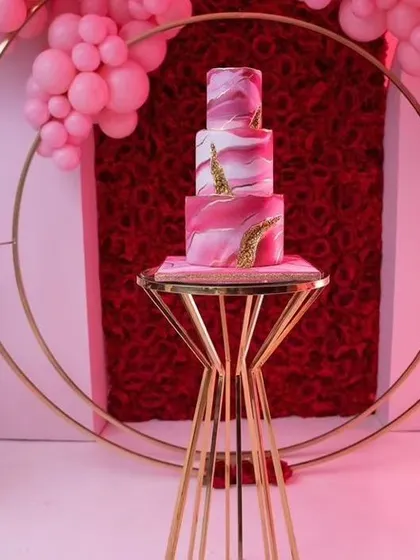 This three-tiered marbled pink cake with gold accents is a work of art. Placed on a modern gold stand, it adds a touch of sophisticated elegance to a princess or milestone birthday party.