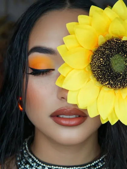 One eye open, one hidden. This creative shot gives a stunning close-up of the blended orange eyeshadow and winged liner.