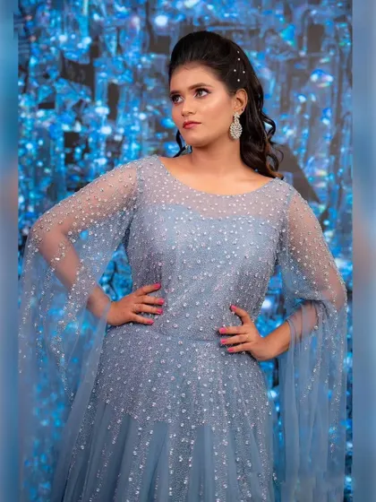 This powder blue gown with its sparkling details and elegant cape sleeves is a whole vibe. It's perfect for a bride who wants a modern yet dreamy look.