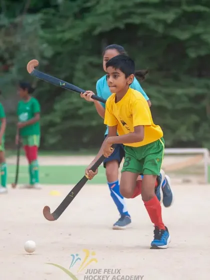 A young boy from our 2022 camp dribbles past a defender, showcasing the skills he learned.