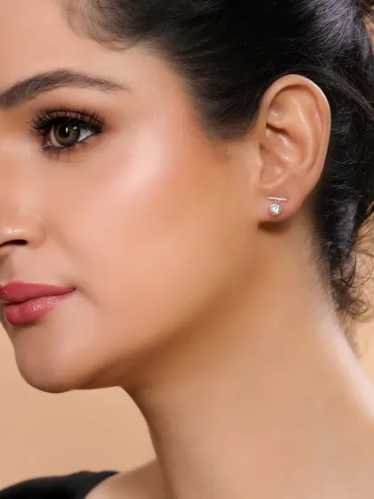 A clean, professional shot of a model wearing minimalist stud earrings, suitable for a corporate or daily wear jewellery line.