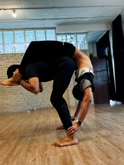 A stunning display of flexibility and strength. This advanced partner pose is the result of dedicated training and incredible body control.