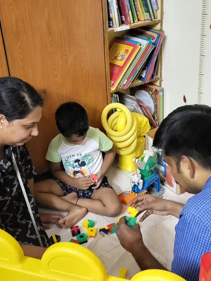 A family completely absorbed in building with colorful blocks. Our toy library is designed to bring families together for quality time and creative fun.