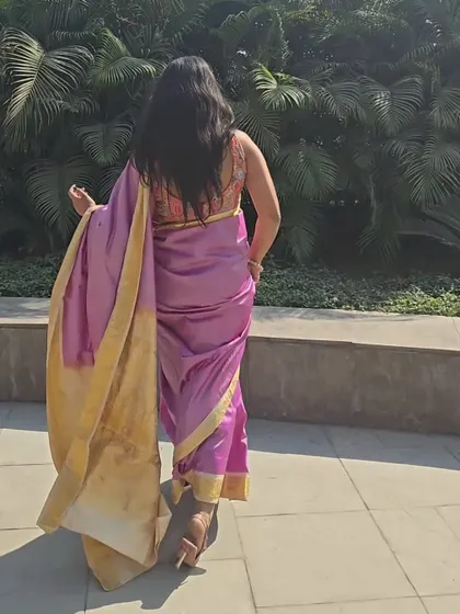 This is the back view of my mom's pink and gold Kanjivaram saree. The focus here is on the beautiful, deep-back blouse with traditional patterns, which adds a lovely contrast to the simple elegance of the saree.