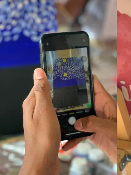 A close-up of a phone capturing a photo of a finished Starry Night painting. It’s a masterpiece worth documenting.
