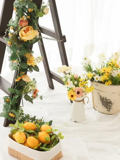 A touch of rustic charm. The combination of the wooden ladder, floral garlands, and baskets of lemons creates a beautiful, layered look for our lemon garden theme.