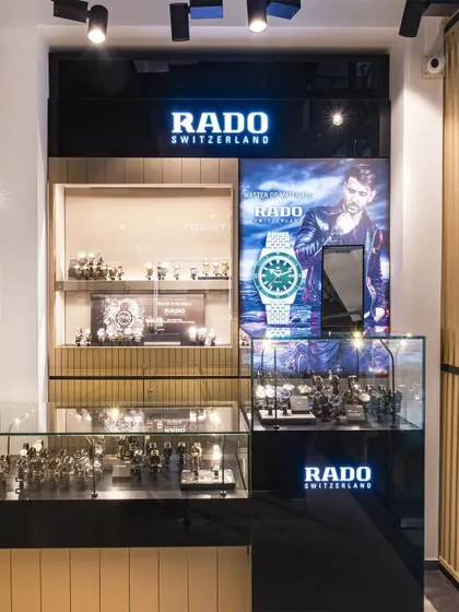 The Rado brand corner, featuring high-gloss black panels and targeted lighting to match the brand's modern and sophisticated identity.
