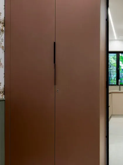 This custom wardrobe was designed for a multi-functional nap room. The clean, handleless design in a warm brown finish complements the room's cozy aesthetic while providing essential storage.