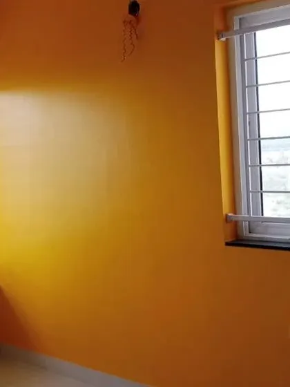A warm, mustard-yellow paint brings brightness to this room, complementing the natural light from the windows.