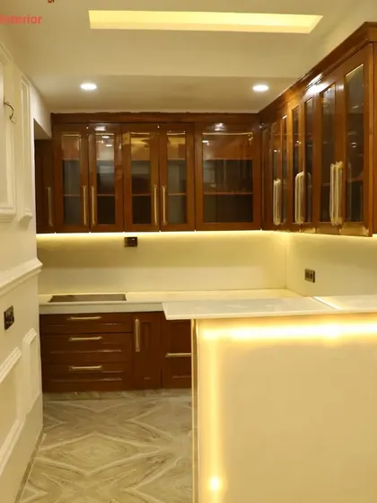A close-up of the classic wooden kitchen from the "fine attention to detail" project, showing the beautiful grain of the wood and the warm under-cabinet lighting.