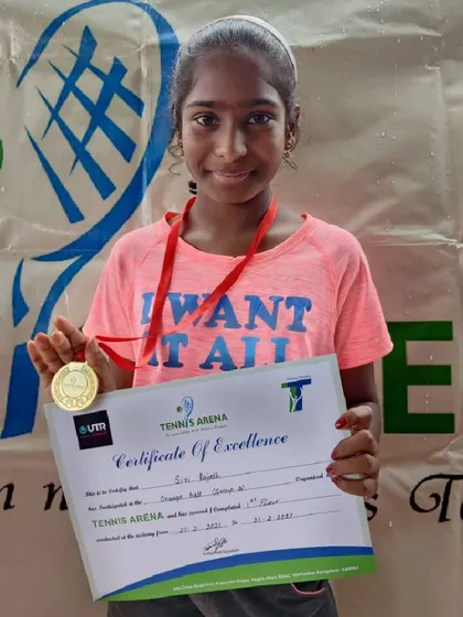 This is what success looks like. A participant from our Orange Ball group proudly holds her medal and certificate after a great performance.