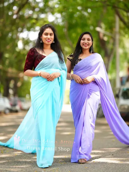 A walking shot of the coordinated blue and lavender trail sarees.