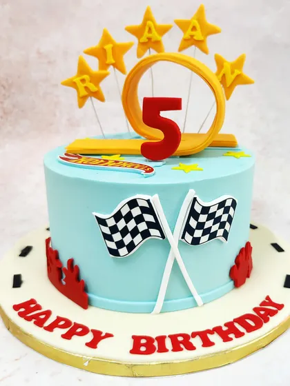 We ignite the excitement of the racetrack with this Hot Wheels themed cake. Featuring the iconic logo, checkered flags, and a fiery loop-the-loop topper, this cake is designed for speed and is the perfect centerpiece for a young racing fan.